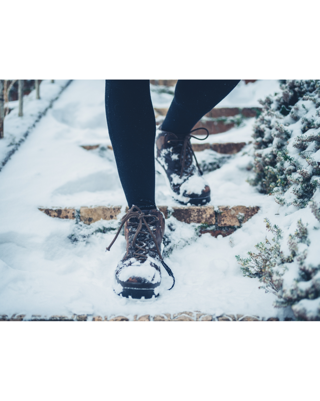 A person walking down snow-covered stairs outside.